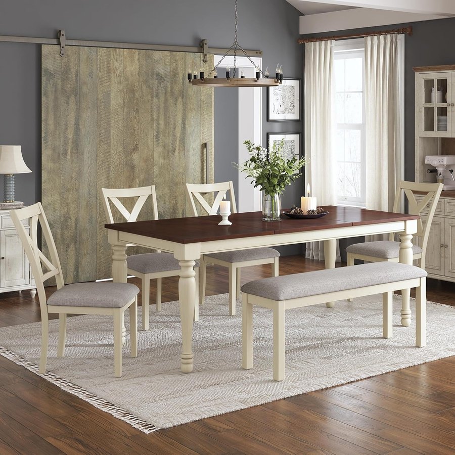 rustic white farmhouse dining table set with four upholstered chairs and a bench