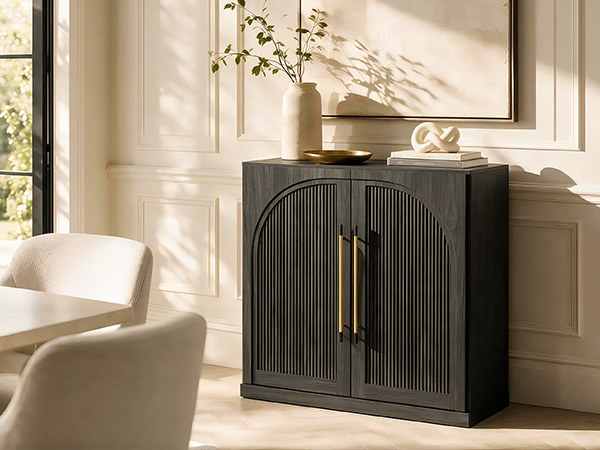 ebony sideboard cabinet with double-arc fluted doors and gold-tone chopstick handles in a dining room setting